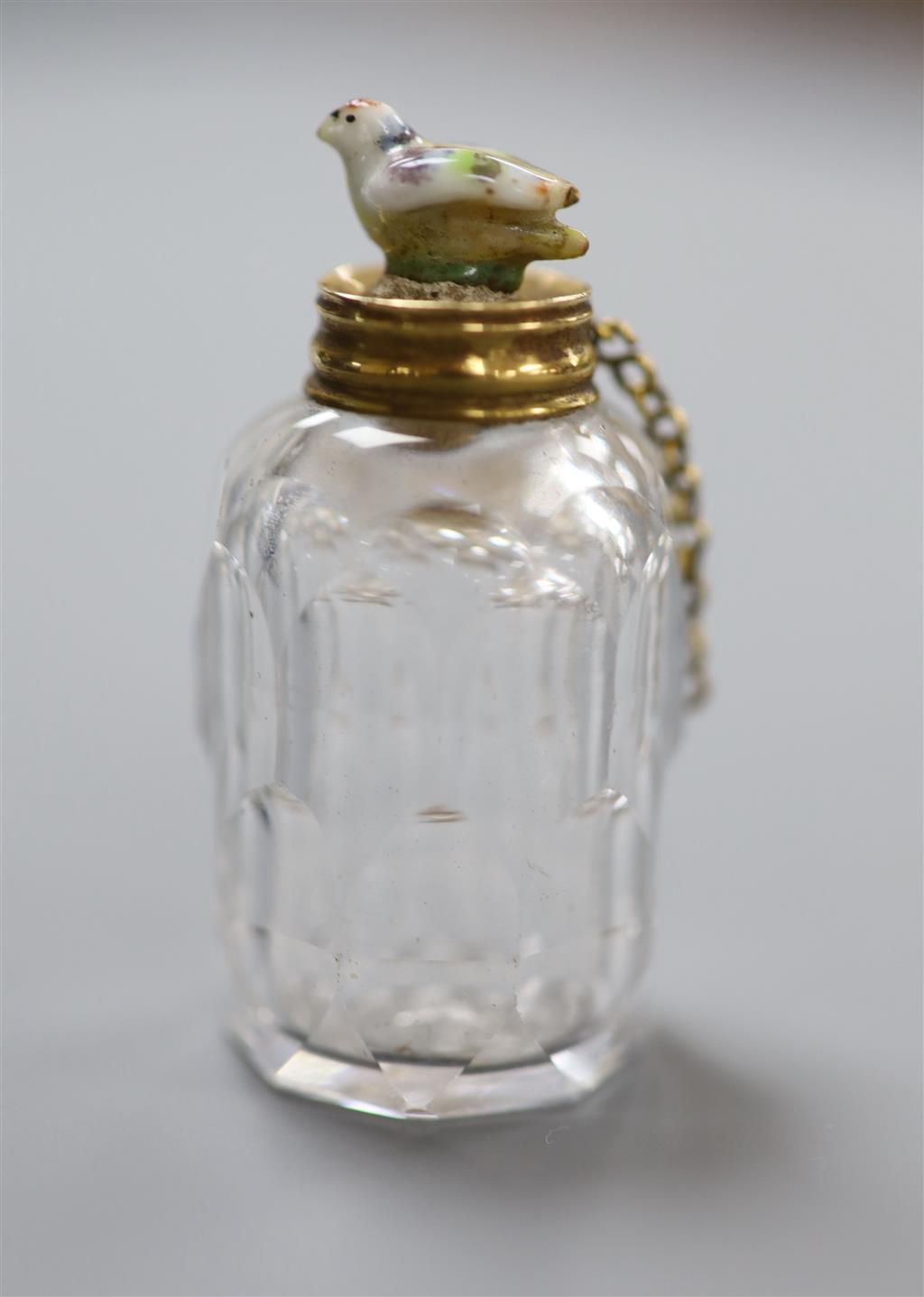 A 19th century yellow metal mounted cut glass scent bottle, with porcelain chick mounted stopper, 41mm.